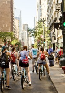 cyclists and pedestrians wait at street crossing in downtown Chicago