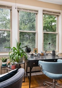 a home office with windows and low bookcases in the sunroom of a Chicago apartment