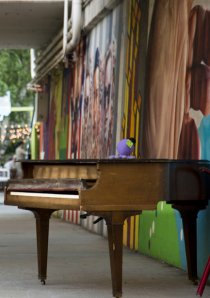 a piano next to a mural painted along a viaduct in the Rogers Park neighborhood of Chicago