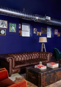 a lounge area of a Chicago apartment building with leather sofa and bookshelves