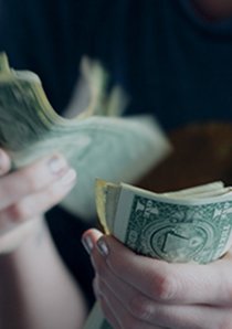 a renter counting US dollar bills by hand