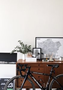 a bicycle leaning against a wooden cabinet in a Chicago apartment