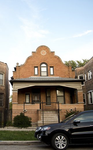 red brick bungalow home with car in front in North Lawndale Chicago