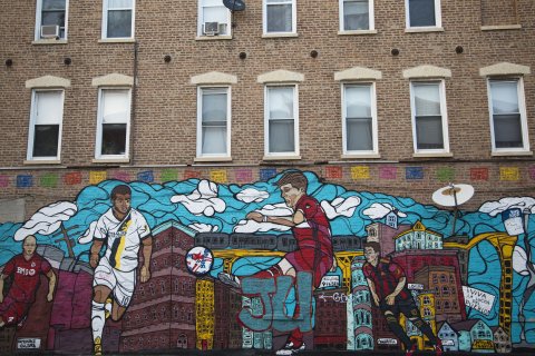 mural on side of apartment building showing MLS Chicago Fire soccer players