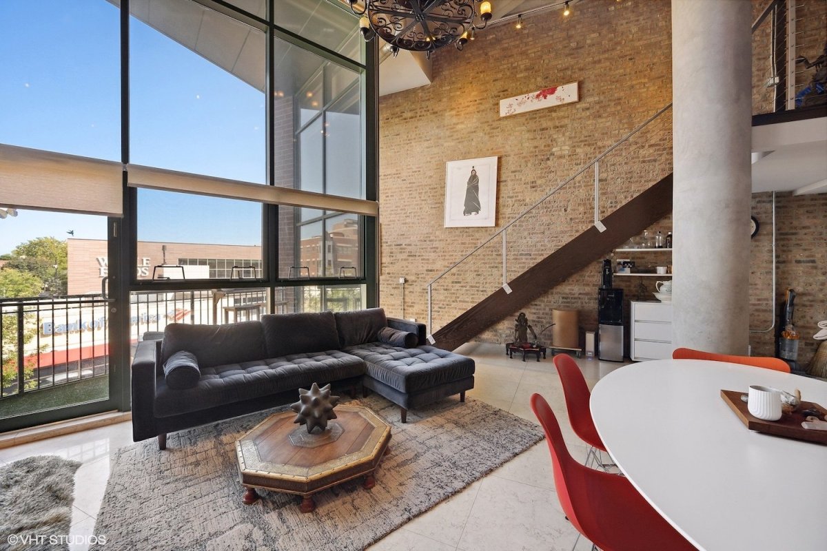 Condo for rent in Lakeview Chicago with two-story windows, exposed brick, and stairs