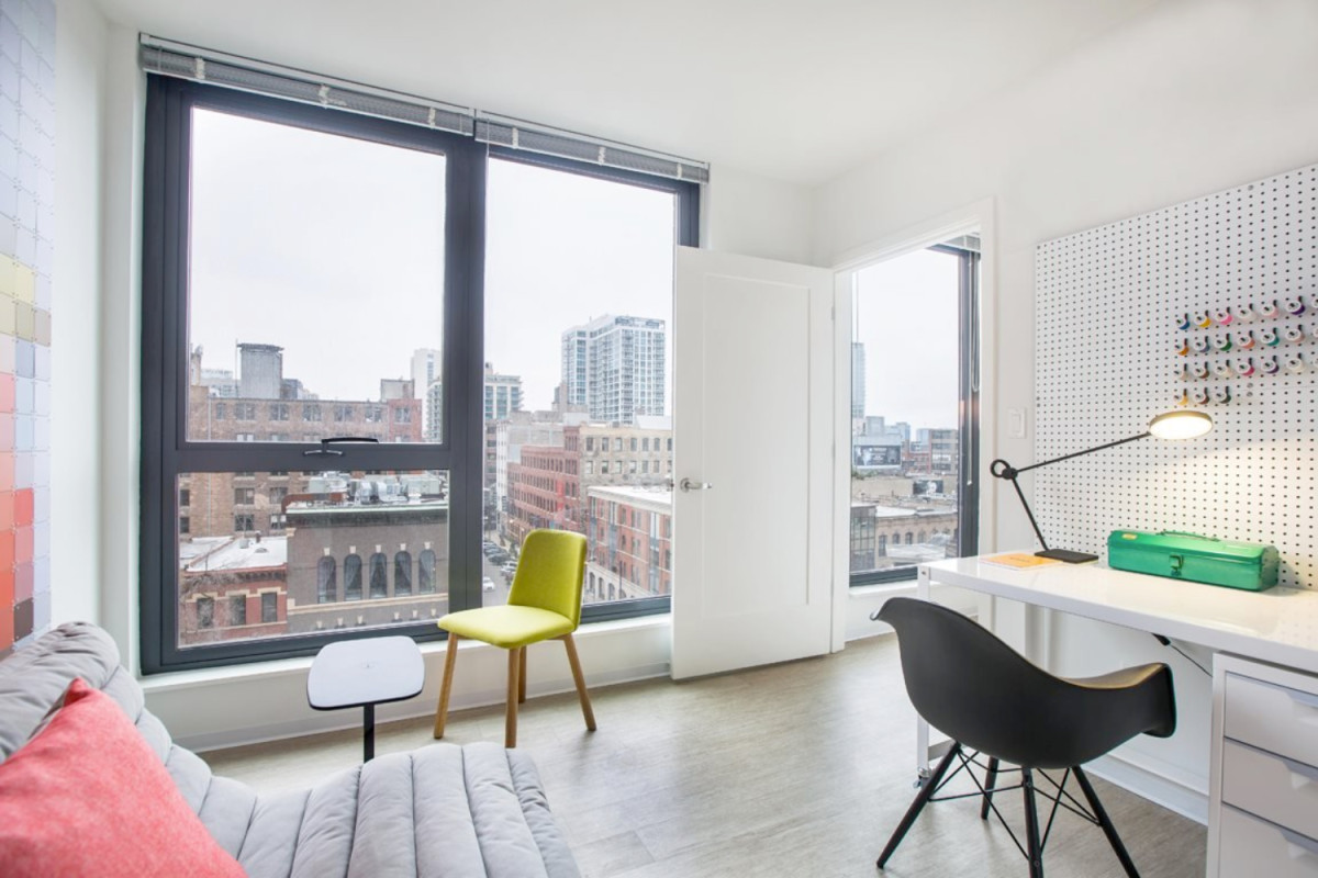 One bedroom apartment with minimalist decor and a desk at Exhibit on Superior apartments in Chicago