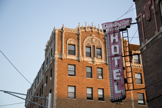 Darlington Hotel with vintage lightbulb sign and apartment buildings in the background in Uptown