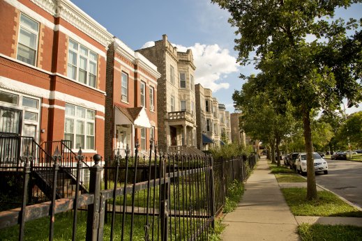Vintage apartments and front lawns on neighborhood street in East Garfield Park Chicago